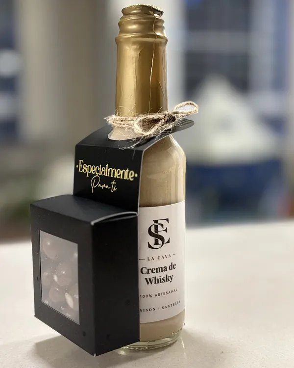 Botella pequeña de Crema de whisky con tarjeta «Especialmente para ti» y una cajita negra con ventana.