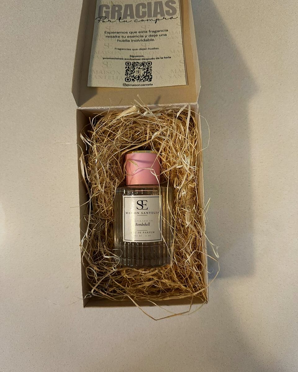 Caja abierta de Maison Santelia con tarjeta de agradecimiento y frasco entre viruta de madera