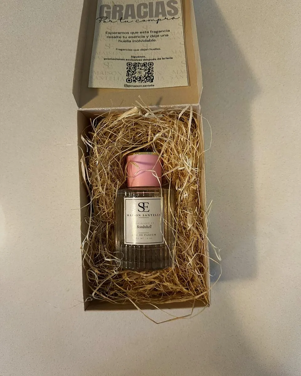 Caja de Maison Santelia abierta: frasco entre viruta de madera y nota de agradecimiento